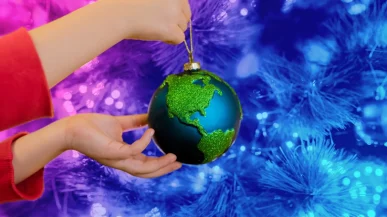 A person holding a globe Christmas bauble