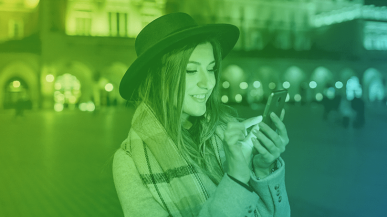 A smiling woman looking at her phone.
