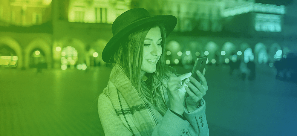 A smiling woman looking at her phone.