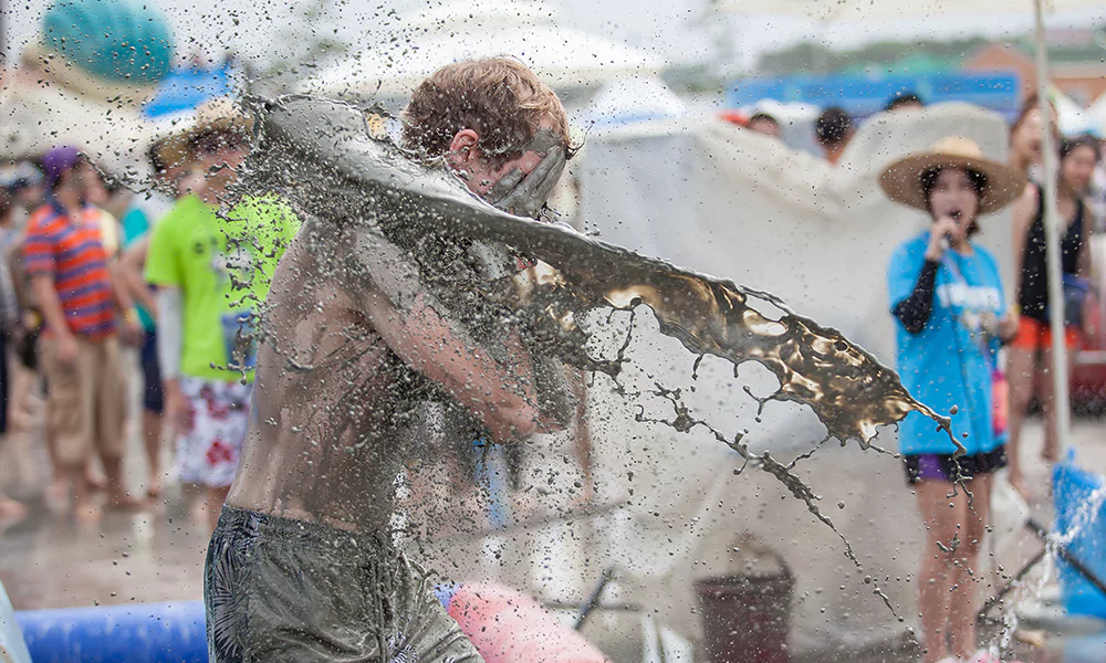 mud being thrown at a man covering face