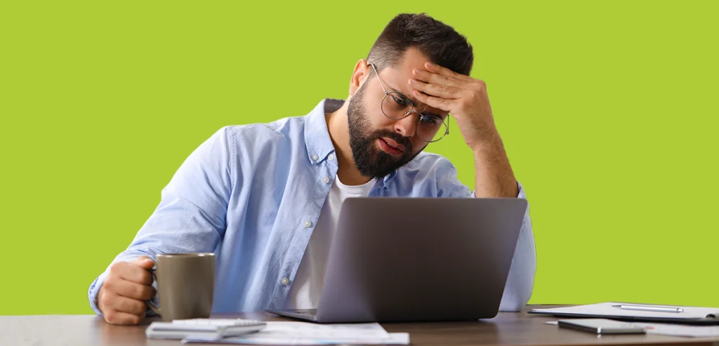 Man looking at laptop screen in frustration