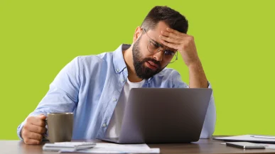 Man looking at laptop screen in frustration
